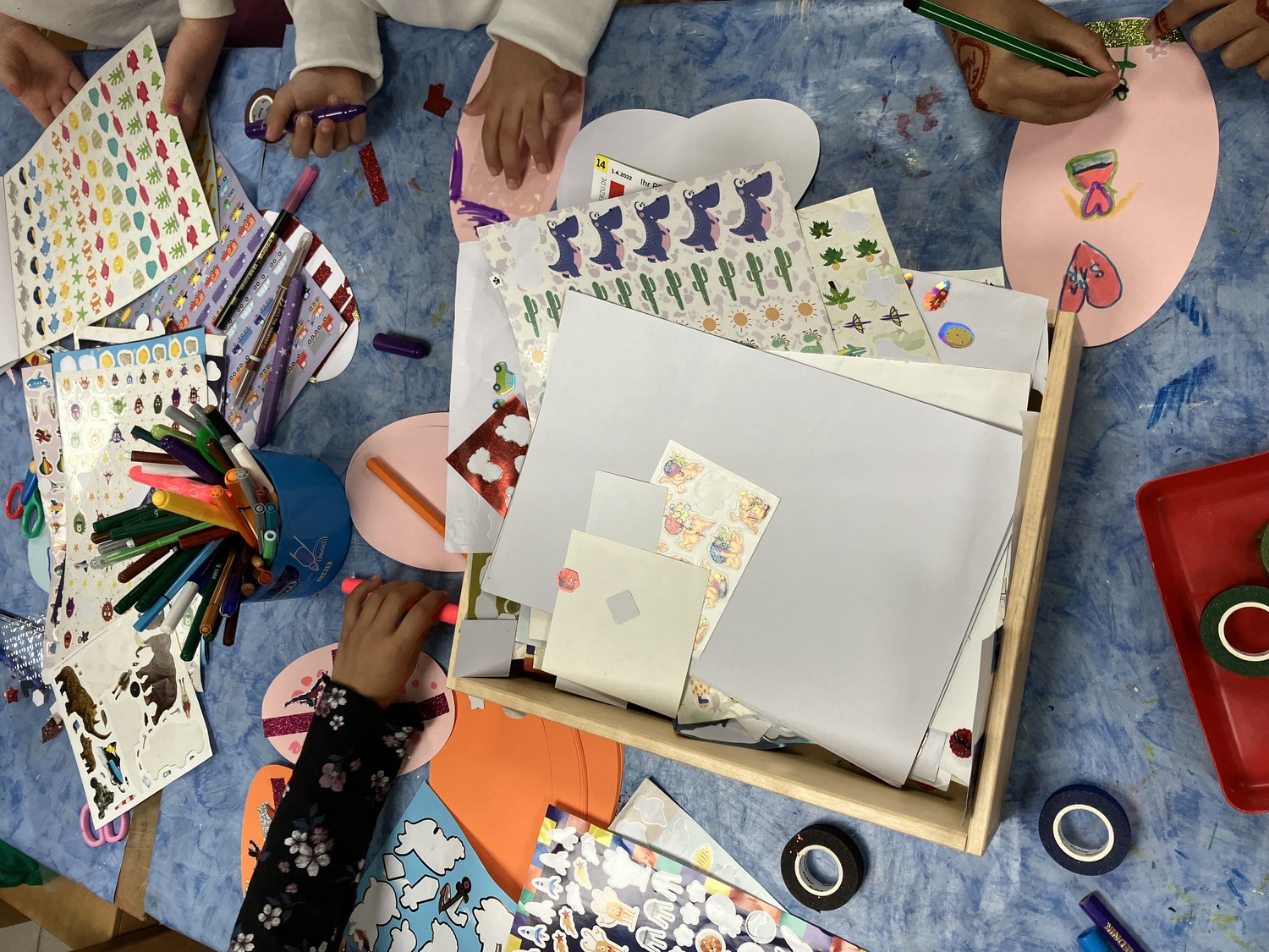Kinder gestalten mit vielfältigen Materialien ihre Blätter